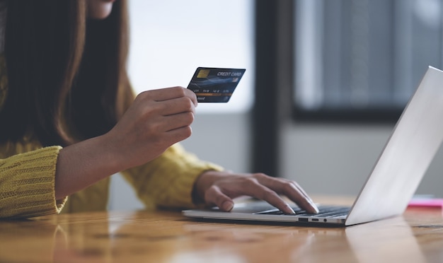 Young woman using laptop computer and holding credit card, Online shopping concept, Credit card online payment.