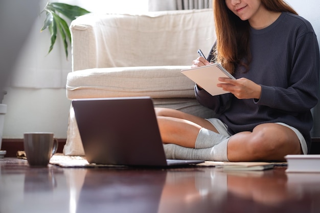 Una giovane donna che utilizza un computer portatile per lavorare o studiare online a casa