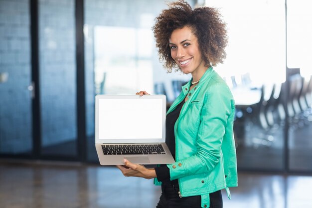 Молодая женщина, используя ноутбук в передней части конференц-зала в офисе