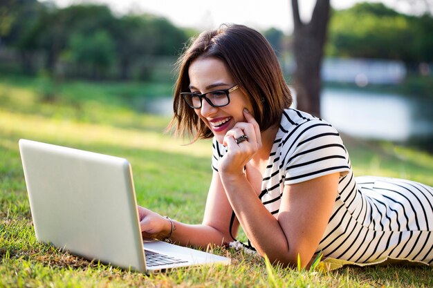 Young woman using laptop in park