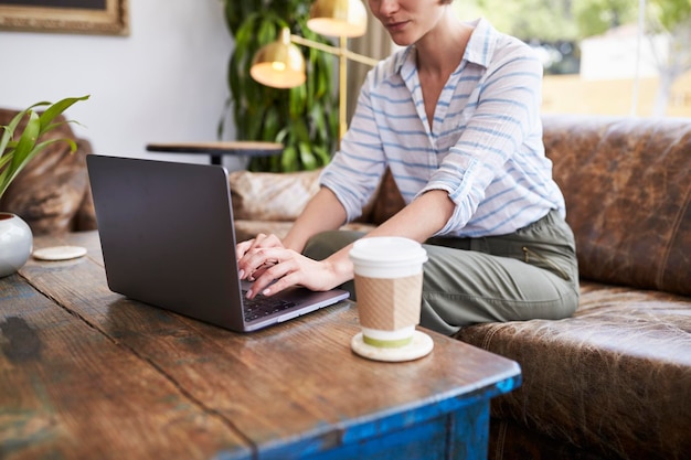 Photo young woman using laptop sitting in a coffee shop