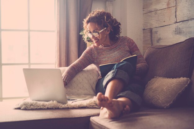 Photo young woman using laptop on sofa at home