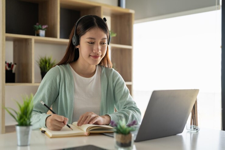 Photo テーブルでラップトップを使っている若い女性