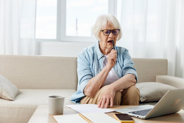 Young woman using laptop while sitting on bed at home