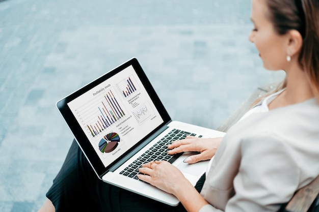 Young woman using a laptop while sitting on a bench