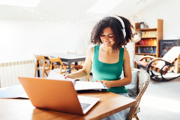 Photo young woman using laptop while sitting on sofa at home