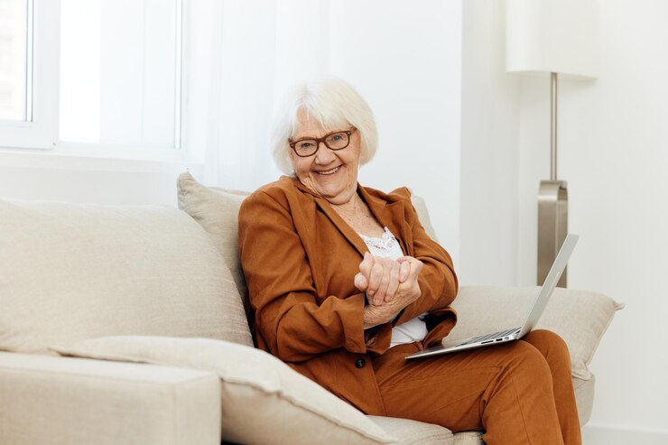 Photo young woman using laptop while sitting on sofa at home