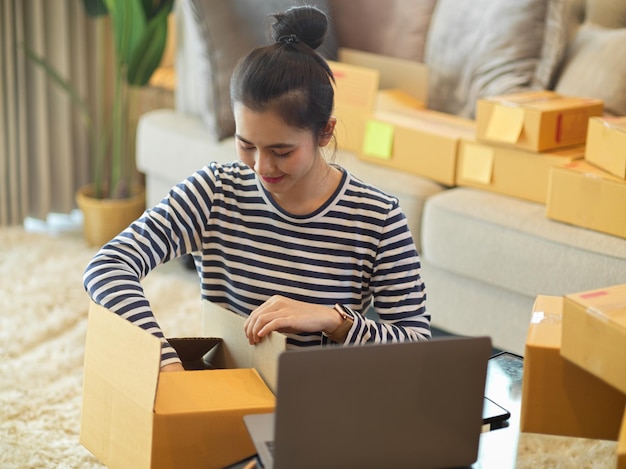 Young woman using laptop while sitting on sofa at home