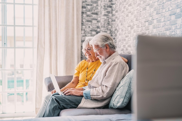 Photo young woman using laptop while sitting on sofa at home