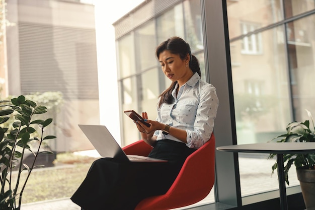 Young woman using laptop while sitting on table