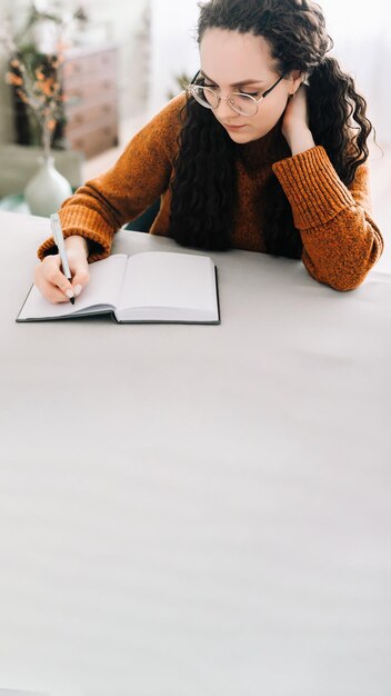 Photo young woman using laptop while sitting on table