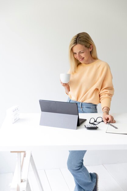 Photo young woman using laptop while sitting on table