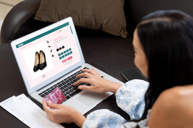 Фото Молодая женщина использует ноутбук с кредитной картой для интернет-банкинга, онлайн-покупок, электронной коммерции с помощью онлайн-платёжного шлюза дома, современных и удобных онлайн-покупок с дебетовой картой blithe