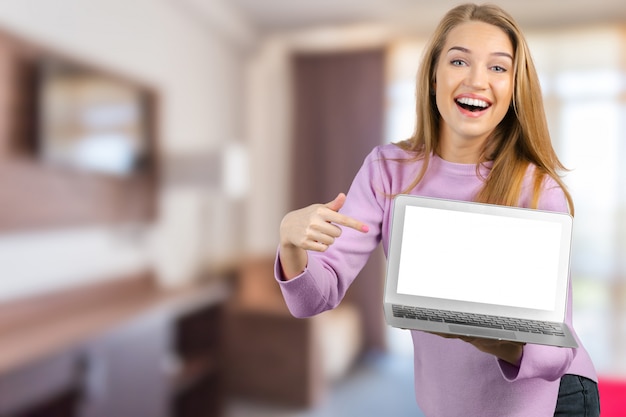 Giovane donna che per mezzo del computer portatile