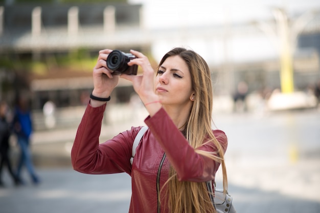 Young woman using a mirrorless camera