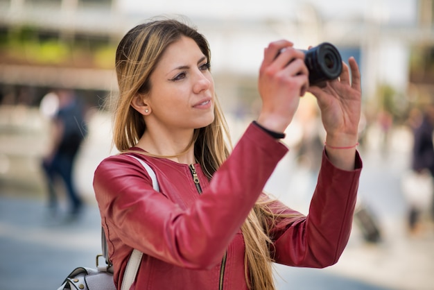 Giovane donna utilizzando una fotocamera mirrorless