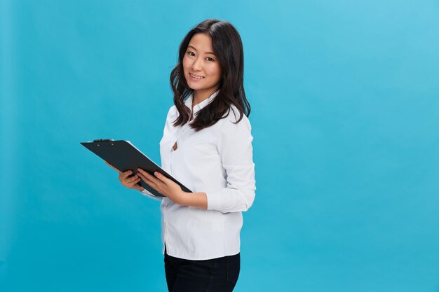 Young woman using mobile phone against blue background