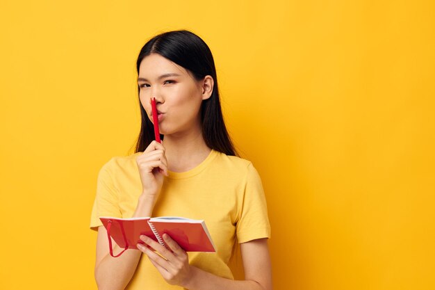 Photo young woman using mobile phone against yellow background