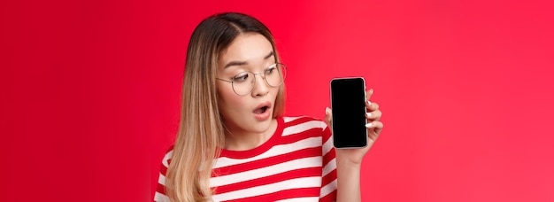 Young woman using mobile phone against yellow background