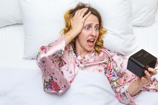 Young woman using mobile phone on bed