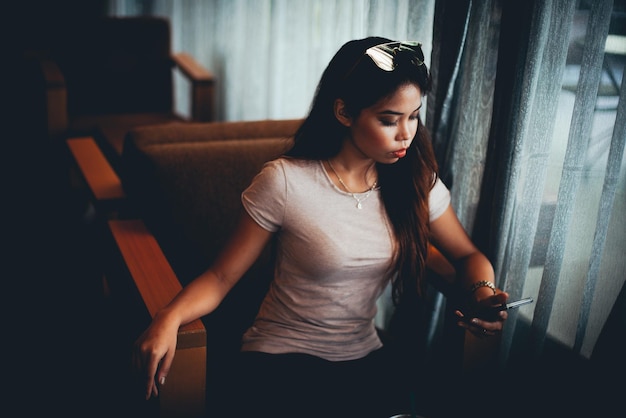 young woman using mobile phone at cafe