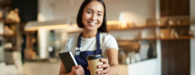 カフェで携帯電話を使っている若い女性