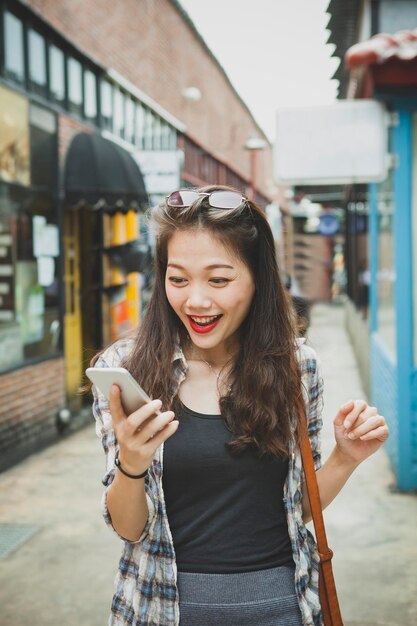 Photo young woman using mobile phone in city