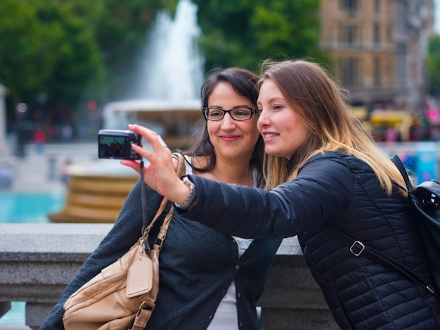 Photo young woman using mobile phone in city