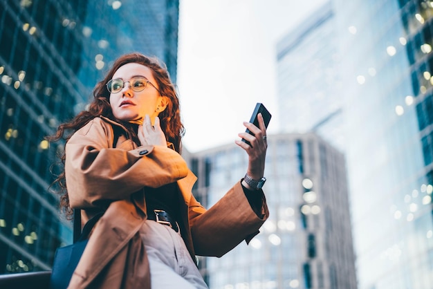 Foto giovane donna che usa il cellulare in città