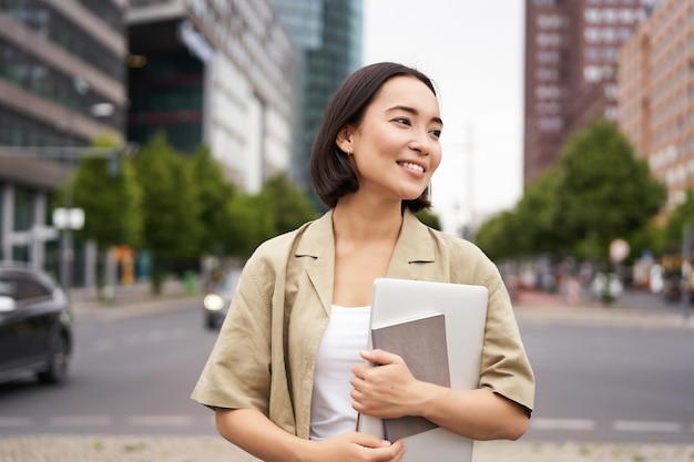 Photo young woman using mobile phone in city