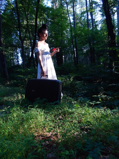 Foto giovane donna che usa il cellulare nella foresta