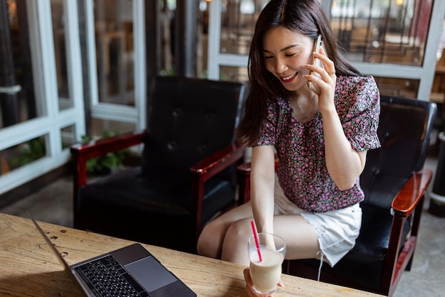 自宅で携帯電話を使っている若い女性