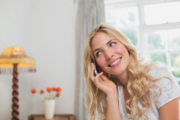 Foto giovane donna con il cellulare a casa