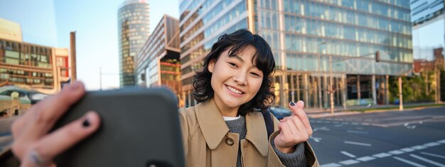 写真 都市で携帯電話を使っている若い女性