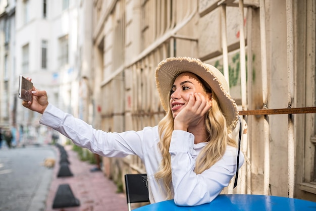 写真 テーブルの上で携帯電話を使っている若い女性