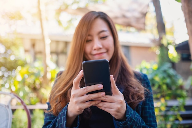 Foto giovane donna che usa il cellulare all'aperto