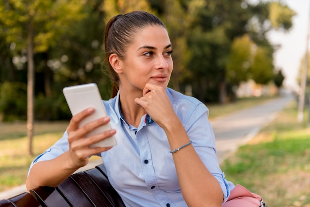 Giovane donna che utilizza telefono cellulare nel parco