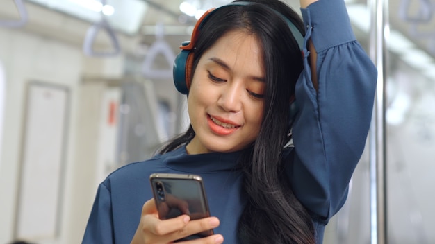公共の電車の中で携帯電話を使用して若い女性