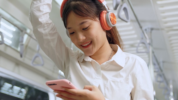 Young woman using mobile phone in public train