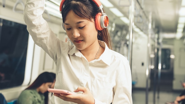 Young woman using mobile phone on public train