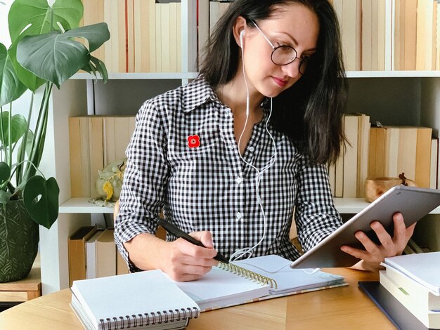 テーブルで携帯電話を使っている若い女性