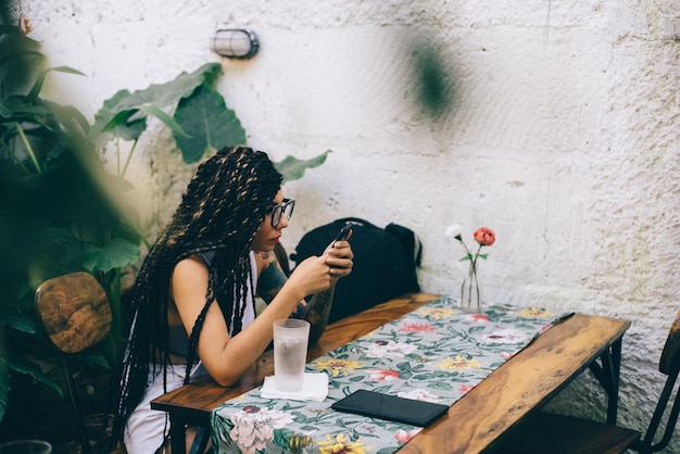 Photo young woman using mobile phone on table