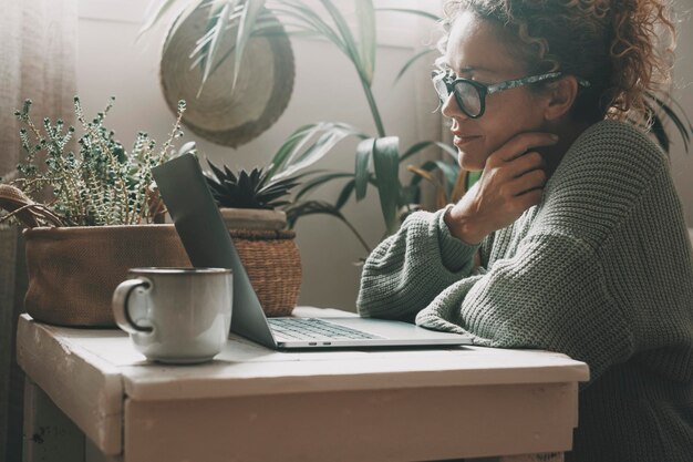 写真 家に座って携帯電話を使っている若い女性