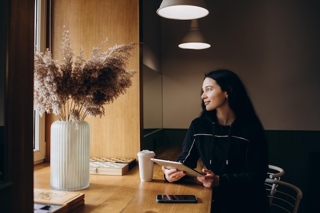 Photo young woman using mobile phone while sitting at home