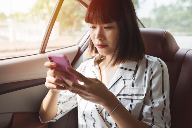 사진 버스에 앉아서 드폰을 사용하는 젊은 여성