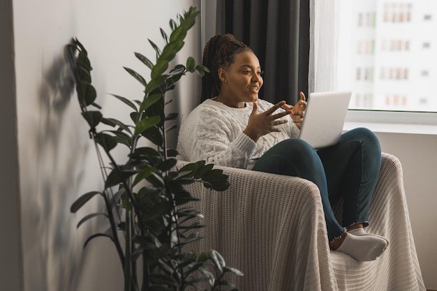 写真 家のソファに座って携帯電話を使っている若い女性