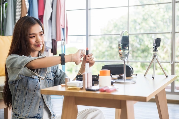 写真 テーブルに座って携帯電話を使っている若い女性