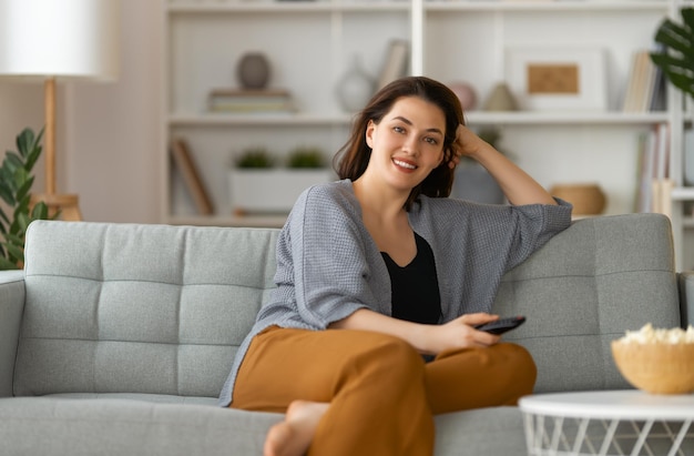 young woman using mobile phone while sitting on sofa at home
