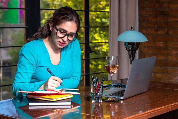 Young woman using mobile phone while sitting on table