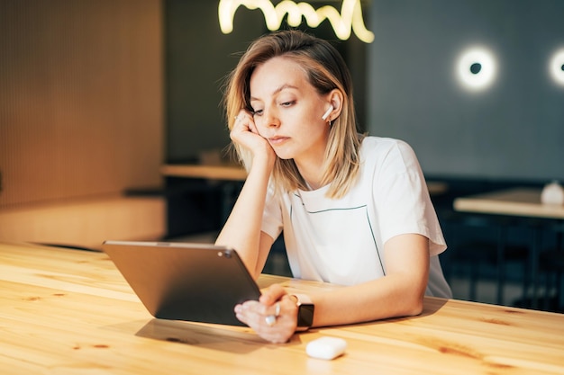 テーブルに座って携帯電話を使っている若い女性